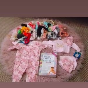 Newborn baby clothes, headbands, and a book.